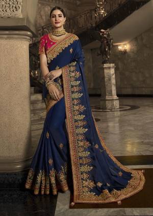 Get Ready For The Upcoming Wedding Season With This Heavy Designer Saree In Dark Blue Color Paired With Contrasting Rani Pink Colored Blouse. This Saree IS Fabricated On Soft Silk Paired With Art Silk Fabricated Blouse. It Is Beautified With Heavy Embroidery Giving You An Attractive Look.
