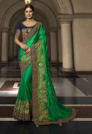 Celebrate This Festive And Wedding Season Adding A Glam To Your Look Wearing This Heavy Designer Saree In Green Color Paired With Contrasting Navy Blue Colored Blouse. This Saree Is Fabricated On Soft Silk Paired With Art Silk Fabricated Blouse. Buy This Saree Now.