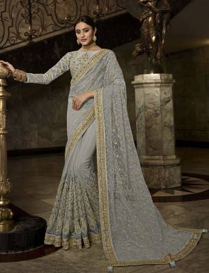 Rich And Elegant Looking Heavy Designer Saree In Grey Color Paired With Grey Colored Blouse. This Heavy Embroidered Saree Is Fabricated On Net Paired With Art Silk Fabricated Blouse. Its Detailed Embroidery And Rich Color Will Give You Heavy And Subtle Look Both At The Same Time. 