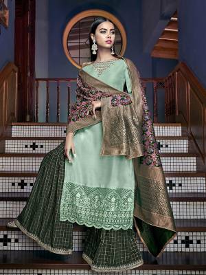 Pretty Shades In Green are Here With This Designer Sharara Suit In Sea Green Colored Top Paired With Dark Green Colored Bottom And Multi Colored Dupatta. Its Top Is Fabricated On Tussar art Silk Paired With Jacqurd Silk Bottom And Dupatta. It Is Beautified With Attractive Embroidery and Weaved Dupatta. 