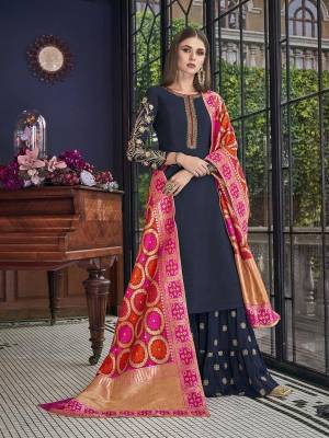 Enhance Your Personality Wearing This Designer Sharara Suit In Navy Blue Color Paired With Contrasting Dark Pink And Orange Colored Dupatta. Its Top Is Fabricated On Soft Art Silk Paired With Georgette Bottom And Jacquard Silk Fabricated Dupatta. It Is Light Weight And Easy To Carry All Day Long. 