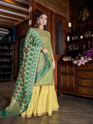 Celebrate This Festive Season With Pretty Colors Wearing This Designer Sharara Suit In Light Green Colored Top Paired With Contrasting Yellow Colored Bottom and Green Colored Dupatta. Its Top Is Fabricated On Art Silk Slub Paired With Muslin Bottom And Jacquard Silk Fabricated Dupatta. 