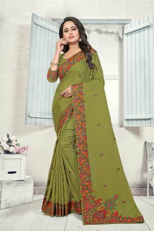 Here Is A Very Pretty Kashmiri Embroidered Designer Saree In Olive Green Color. This Pretty Saree And Blouse Are Silk Based With Heavy Embroidered Multi Colored Lace Border. 