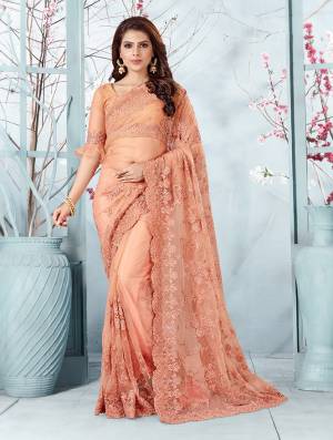 Here Is A Very Beautiful And Heavy Designer Saree In Peach Color. This Beautiful Heavy Embroidered Saree And Blouse Are Fabricated On Net Beautified With Pretty Tone To Tone Resham Embroidery And Ceramic Stone Work. Buy This Heavy Yet Subtle Looking Saree Now.