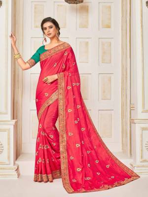 Shine Bright Wearing This Designer Silk Based Saree In Dark Pink Color Paired With Contrasting Teal Green Colored Blouse. It Is Beautified With Embroidered Small Butti With Jacqurd Lace Border All Over, Buy Now.