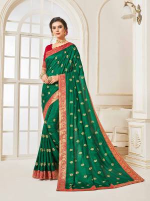 For A Proper Traditional Look, Grab This Designer Silk Based Saree In Dark Green Color Paired With Contrasting Red Colored Blouse. Its Rich Fabric And Color Will Earn You Lots Of Compliments From Onlookers.