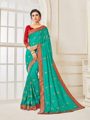 Grab This Very Beautiful Designer Saree In Turquoise Blue Color Paired With Contrasting Red Colored Blouse. This Saree And Blouse Are Silk Based Beautified With Embroidered Butti and Lace Border. Buy This Pretty Saree Now.