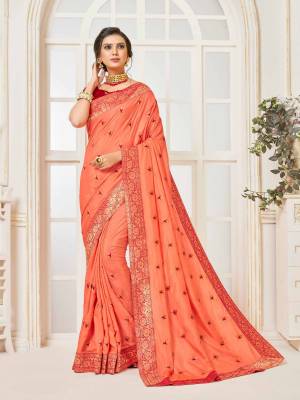 Grab This Very Beautiful Designer Saree In Dark Peach Color Paired With Contrasting Red Colored Blouse. This Saree And Blouse Are Silk Based Beautified With Embroidered Butti and Lace Border. Buy This Pretty Saree Now.