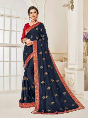 Enhance Your Personality Wearing This Designer Silk Based Saree In Navy Blue Color Paired With Contrasting Red Colored Blouse. Its Rich Fabric Is Light Weight And Durable And Gives A Royal Look To Your Personality. 
