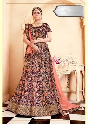 Be The Prettiest Bride Wearing This Very Beautiful And Heavy Embroidered Designer Bridal Lehenga Choli In Purple Color Paired With Contrasting Dark Peach Colored Dupatta. This Lehenga Choli Is Velvet Based Paired With Net Fabricated Dupatta. Buy This Beautiful Lehenga Choli Now.