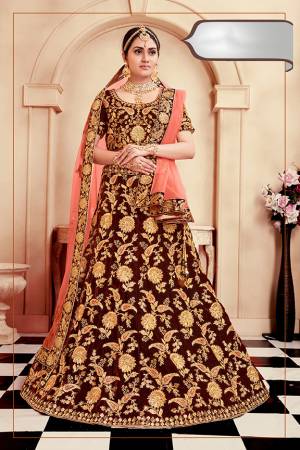 Get Ready For Your D-Day With This Heavy Designer Bridal Lehenga Choli In Maroon Color Paired With Contrasting Dark Peach Colored Dupatta. Its Heavy Embroidered Blouse And Lehenga Are Fabricated On Velvet Paired With Net Fabricated Dupatta. 