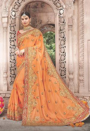 Celebrate This Festive And Wedding With All Jazz Wearing This Heavy Embroidered Designer Saree In Orange Color Paired With Contrasting Red Colored Blouse. This Saree And Blouse Are Silk Based Which Gives A Rich Look To Your Personality. 
