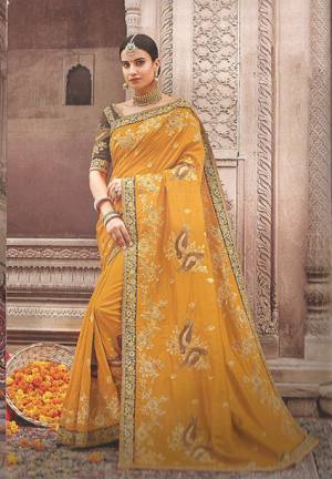 Get Ready For The Upcoming Festive And Wedding Season With This Beautiful Designer Saree In Musturd Yellow Color Paired With Contrasting Brown Colored Blouse. This Saree And Blouse Are Silk Based Beautified With Attractive Embroidery Which Will Earn You Lots Of compliments From Onlookers.