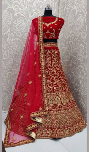 Here Is A Heavy Embroidered Designer Bridal Lehenga Choli For Your D-Day. This Heavy Velvet Based Lehenga Choli Is In Red Color Paired With Red Colored Net Fabricated Dupatta. It Is Beautified With Heavy Jari And Coding Embroidery With Stone Work. 