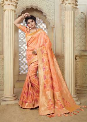 Celebrate This Festive Season With Beauty And Comfort Wearing This Pretty Silk Based Saree In Peach Color Paired With Peach Colored Blouse. This Saree And Blouse Are Fabricated On Banarasi Art Silk Beautified With Weave All Over. 