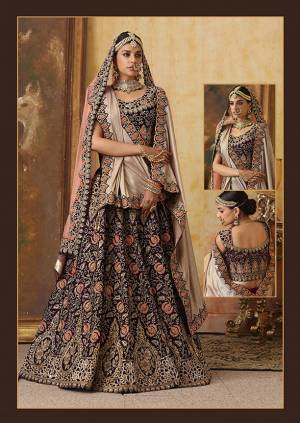 Get Ready For Your D-Day With This Heavy Designer Bridal Lehenga?Choli In Dark Wine Color Paired With Contrasting Baby Pink Colored Dupatta. Its Heavy Embroidered Blouse And Lehenga Are Fabricated On Velvet Paired With Net Fabricated Dupatta.