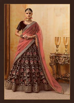 Get Ready For Your D-Day With This Heavy Designer Bridal Lehenga?Choli In Maroon Color Paired With Contrasting Peach Colored Dupatta. Its Heavy Embroidered Blouse And Lehenga Are Fabricated On Velvet Paired With Net Fabricated Dupatta