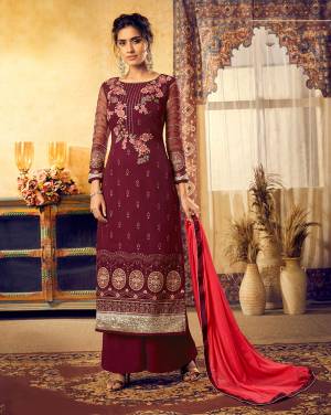 Here Is A Royal Looking Heavy Straight Suit In Maroon Color Paired With Red Colored Dupatta. Its Top Is Fabricated On Georgette Beautified With Heavy Embroidery Paired With Santoon Bottom And Chiffon Fabricated Dupatta. 