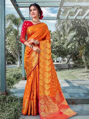 This Festive Adorn A Proper Traditional Look Wearing This Silk Based Saree In Orange Color Paired With Contrasting Red Colored Blouse. This Saree And Blouse are Fabricated On Art Silk Beautified With Weave All Over. 