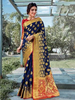 This Festive Adorn A Proper Traditional Look Wearing This Silk Based Saree In Navy Blue Color Paired With Contrasting Red Colored Blouse. This Saree And Blouse are Fabricated On Art Silk Beautified With Weave All Over. 