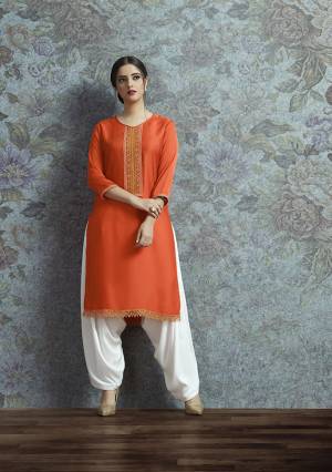 Celebrate This Festive Season With A New Indo-Western Look Wearing This Pair Of Kurti In Orange Color Paired With White Colored Bottom. Its Top Is Fabricated On Modal Satin Beautified With Embroidered Lace Border Paired With Crepe Fabricated Unstitched Bottom. Buy This Lovely Pair Now.