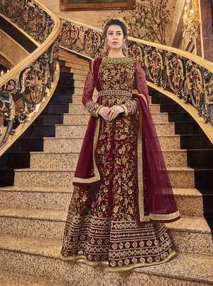 Here Is A Royal Looking Heavy Designer Floor Length Suit In Maroon Color. Its Heavy Embroidered Top Is Fabricated On Net Paired With Art Silk Fabricated Bottom And Net Fabricated Dupatta. Its Royal Color and Pattern Will Earn You Lots Of Compliments From Onlookers.