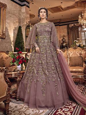 New Shade In Purple Is Here With This Heavy Designer Floor Length Suit In Mauve Color. This Beautiful Patterned And Heavy Embroidered Floor Length Top Is Fabricated On Net Paired With Santoon Bottom And Net Fabricated Dupatta. Buy Now.