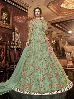 Add This Beautiful Designer Floor Length Suit To Your Wardrobe With A Quite Unique Pattern In Light Green Color. Its Top IS Fabricated On Net Paired With Muslin Bottom And Net Fabricated Dupatta. Its Top Is Beautified With Contrasting Work Which Gives A Attractive Look To The Dress. 