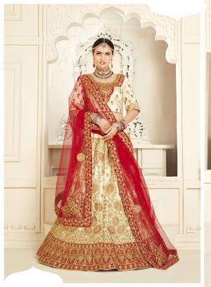 Flaunt Your Rich And Elegant Taste Wearing This Very Beautiful Heavy Designer Bridal Lehenga Choli In Cream Color Paired With Red Colored Dupatta. Its Blouse And Lehenga Are Satin Silk Based Paired With Net fabricated Dupatta. 