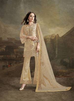 Look Pretty In This Designer Suit In Elegant Beige Color. Its Top, Bottom And Dupatta Are Fabricated On Net. It Is Beautified With Subtle Tone To Tone Resham Embroidery Highlighted With Jari & Stone Work. 