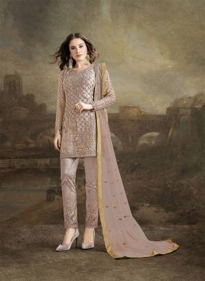 Look Pretty In This Designer Suit In Pretty Dusty Mauve Color. Its Top, Bottom And Dupatta Are Fabricated On Net. It Is Beautified With Subtle Tone To Tone Resham Embroidery Highlighted With Jari & Stone Work. 