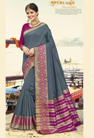 Flaunt Your Rich And Elegant Taste Wearing This Designer Saree In Dark Grey Color Paired With Contrasting Rani Pink Colored Blouse. This Saree Is Fabricated On Cotton Silk Paired With Art Silk Fabricated Blouse. It Is Beautified With Weaved Border. 