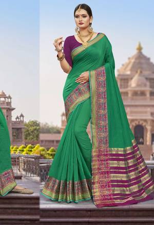 Flaunt Your Rich And Elegant Taste Wearing This Designer Saree In Green Color Paired With Contrasting Purple Colored Blouse. This Saree Is Fabricated On Cotton Silk Paired With Art Silk Fabricated Blouse. It Is Beautified With Weaved Border. 