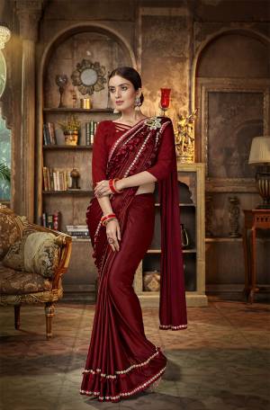 Here Is A Royal Looking Designer Saree In Maroon Color Paired With Maroon Colored Blouse. This Saree Is Fabricated On Lycra Paired With Art Silk Fabricated Blouse. It Is Bautified With Hand Work Patch And Fancy Lace Border. 