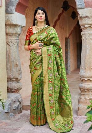 Here Is A Royal Looking Heavy Weaved Designer Saree In Green Color Paired With Contrasting Red Colored Blouse. This Saree And Blouse Are Fabricated On Banarasi Art Silk Which Gives A Rich Look To Your Personality. 