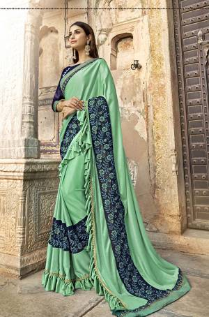 Add This Very Beautiful Designer Saree In Lovely Sea Green Color Paired With Navy Blue Colored Blouse. This Saree Is fabricated On Lycra Paired With Art Silk Fabricated Blouse. Its Fabric Is Light Weight, Durable And Easy To Carry Throughout The Gala