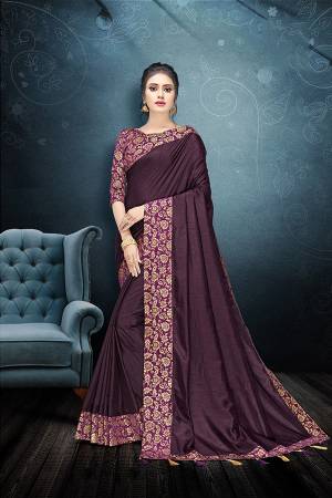 Here Is A Rich And Elegant Looking Designer Saree In Wine Color Paired With Purple Colored Blouse. This Saree And Blouse Are Silk Based Beautified With Lace Border And Tassels Over The Pallu Border. 