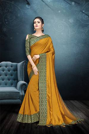 Here Is A Rich And Elegant Looking Designer Saree In Musturd Yellow Color Paired With Green Colored Blouse. This Saree And Blouse Are Silk Based Beautified With Lace Border And Tassels Over The Pallu Border. 
