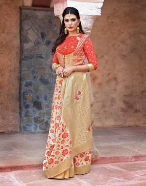 Look like an embodiment of panache and grace in this simple and sophisticated cream and orange floral weaved silk saree with a brocade blouse and embroidered jacket. 
