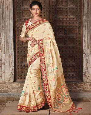 The cream-and-red silk weaved saree exudes absolute divinity and panache. Pair it with or without jacket and look divine. 