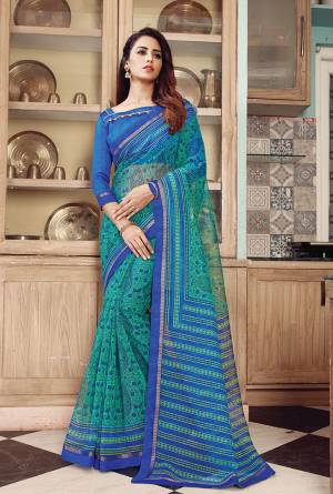 For Your Casual Or Semi-Casual Wear, Grab This Printed Saree In Green Color Paired With Blue Colored Blouse. This Saree Is Super Net Based Paired With Art Silk Fabricated Blouse. Buy Now. 
