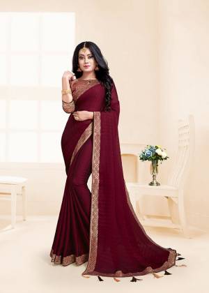 Here Is A Rich And Elegant Looking Designer Saree In Maroon Color Paired With Maroon Colored Blouse. This Saree And Blouse Are Silk Based Beautified With Lace Border And Tassels Over The Pallu Border.