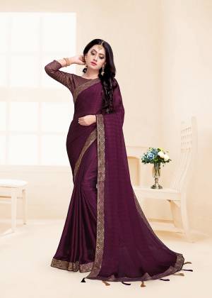 Here Is A Rich And Elegant Looking Designer Saree In Wine Color Paired With Wine Colored Blouse. This Saree And Blouse Are Silk Based Beautified With Lace Border And Tassels Over The Pallu Border.