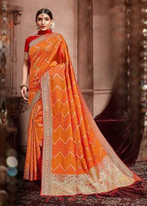 Celebrate This Festive In A Traditional Look Wearing This Designer Saree In Orange Color Paired With Contrasting Red Colored Blouse. This Saree And Blouse Are Silk Based Beautified With Weave. Buy This Saree Now.