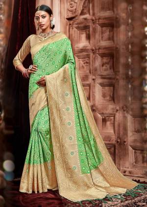 Add This Pretty Saree To Your Wardrobe In Green Color Paired With Beige Colored Blouse. This Saree And Blouse Are Silk Based Beautified With Heavy Deatiled Weave All Over It. 