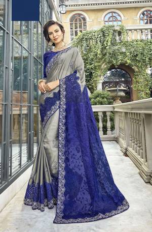 You Will Definitely Earn Lots Of Compliments Wearing This Attractive Looking Heavy Designer Saree In Grey Color Paired With Royal Blue Colored Blouse. This Pretty Detailed Embroidered Saree Is Satin Georgette Based Paired With art Silk Fabricated Embroidered Blouse. 