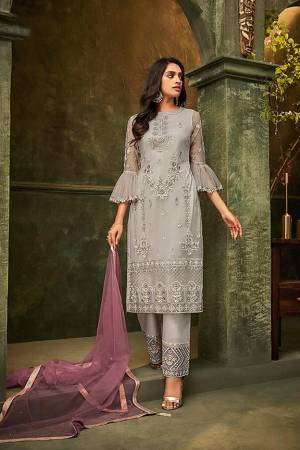 New And Unique Patterned Designer Suit Is Here In Grey Colored Embroidered Top And Bottom Paired With Light Purple Colored Dupatta. Its Top and Dupatta are Net Based Paired With Santoon Fabricated Bottom. Its Pretty Top And Bottom Are Beautified With Detailed Tone To Tone Embroidery. Buy Now.