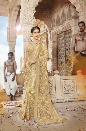 Here Is A Royal Looking Designer Saree In Golden Color. This Saree Is Fabricated On Lycra And Net Paired With Art Silk Fabricated Blouse. Its Fabric Is Durable And Easy To Care For. It Lovely Tone To Tone Embroidery Gives A Subtle Look To The Saree. 