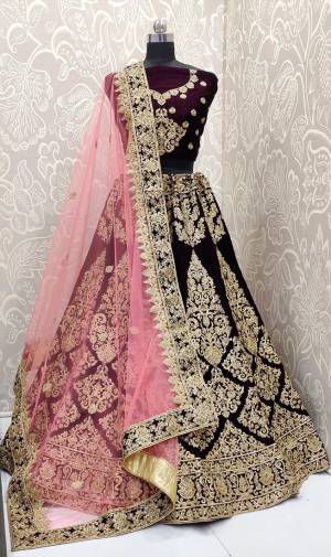 Here Is A Beautiful Designer Bridal Lehenga Choli In Dark Purple Color Paired With Baby Pink Colored Dupatta. This Beautiful Heavy Lehenga Choli Is Fabricated On Velvet Paired With Net Fabricated Dupatta. It Is Beautified With Heavy Detailed Embroidery. Get Ready For Your D-Day With This Designer Piece And Look The Most Graceful Of All. 
