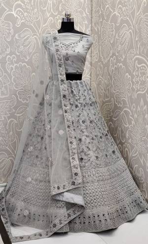 This Wedding Season, Look The Most Graceful Of All Wearing This Heavy Designer Elegant Lehenga Choli In Grey Color. Its Blouse, Lehenga And Dupatta are Fabricated on Net Beautified With Tone To Tone Coding And Resham Embroidery With Stone Work. Its Pretty Elegant Color And Tone-To-Tone Work Will Definitely Earn You Lots Of Compliments From Onlookers. 